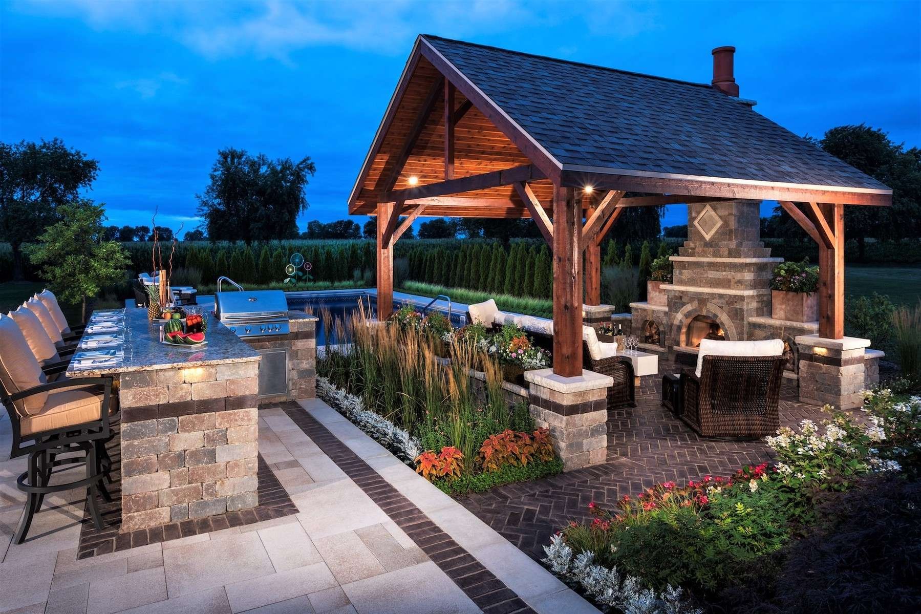 outdoor kitchen and pavilion with fireplace and pool