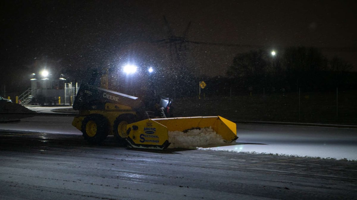 commercial snow removal team plows snow at property