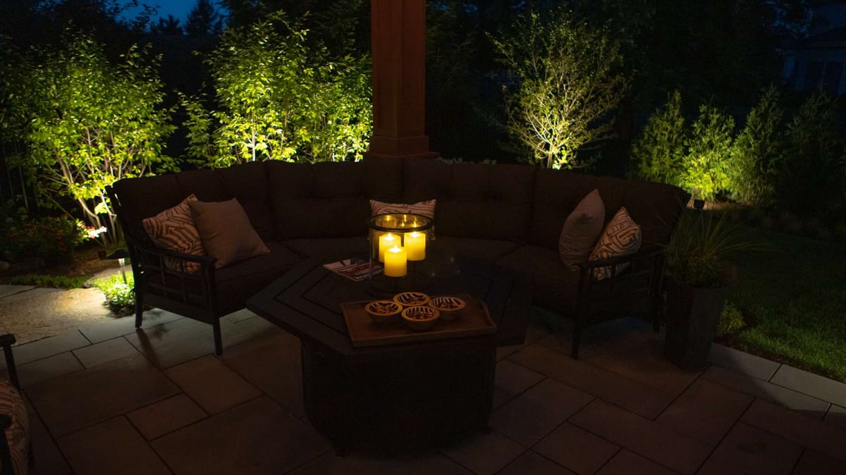 landscape lighting around patio with seating area