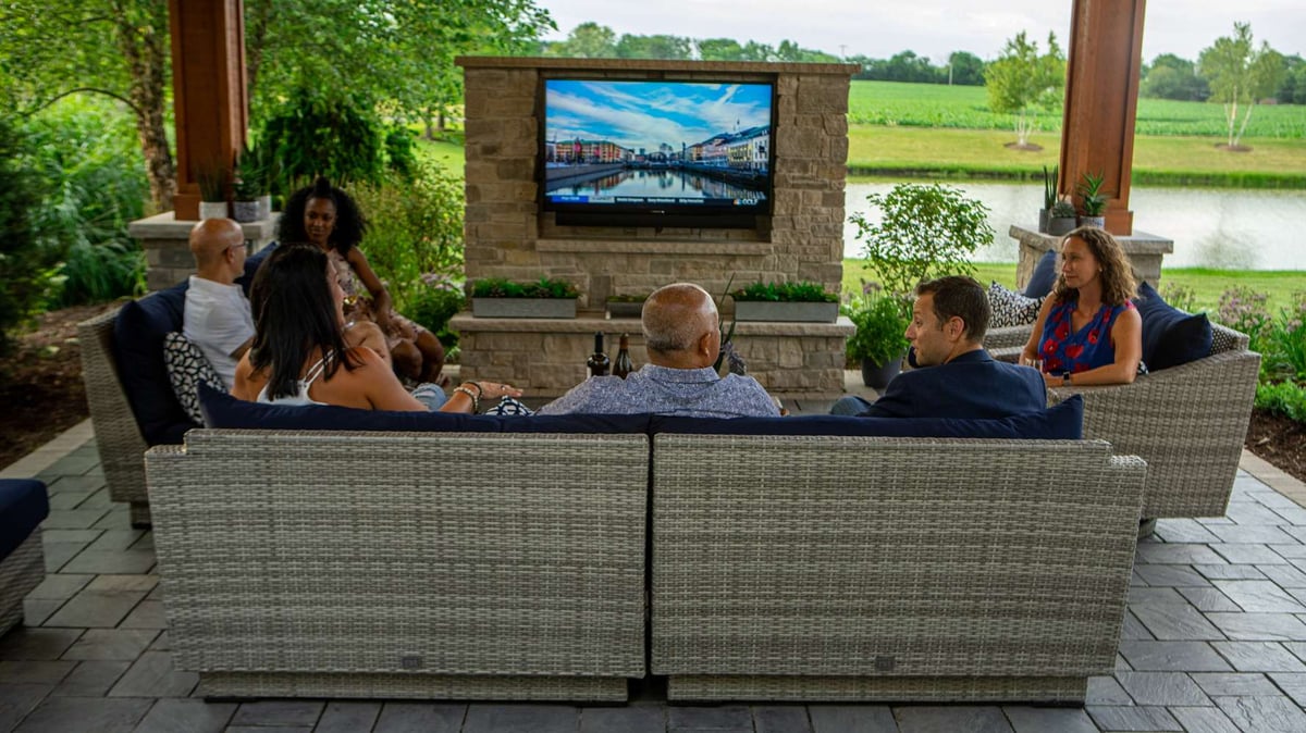 family watches television on patio under pavilion