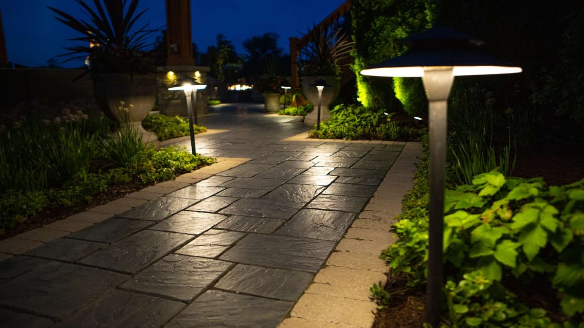 walkway with landscaping lighting and plantings