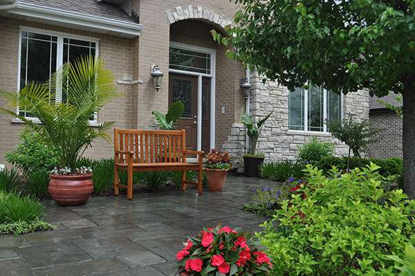 front entrance to home with variety of plant materials and colorful flowers
