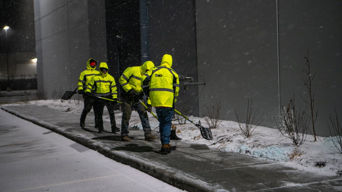snow removal team shovels walkways at commercial property