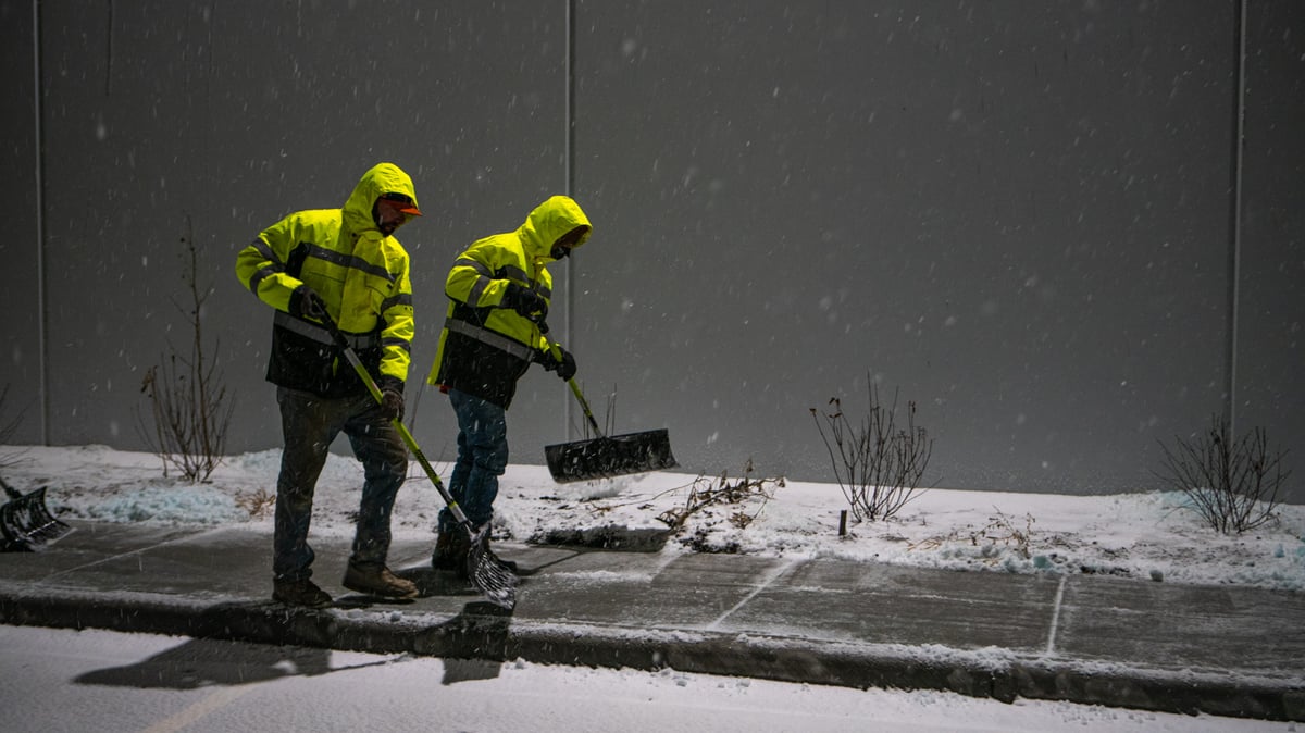 snow removal team shovels snow off sidewalks