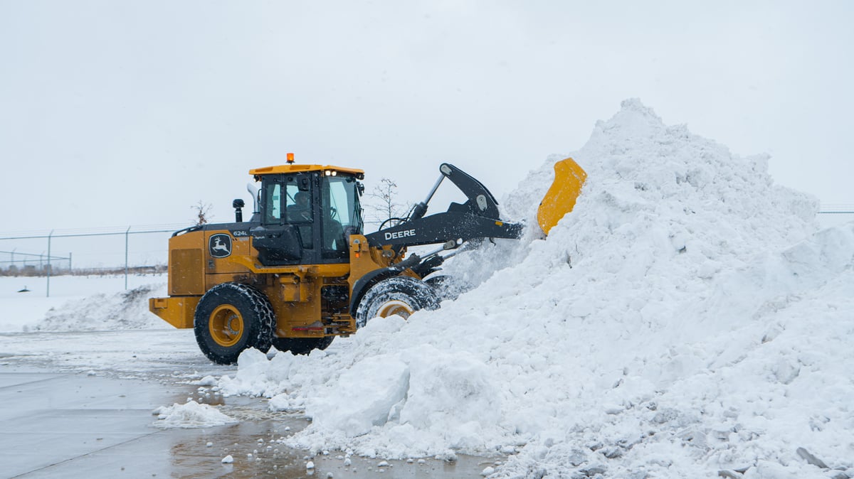 front loader piles snow at commercial property