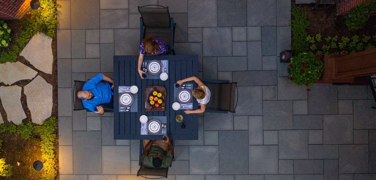 family enjoying dinner on bluestone patio aerial view